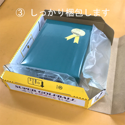 緩衝材を使って名入れゴルフボールをしっかりと梱包いたします